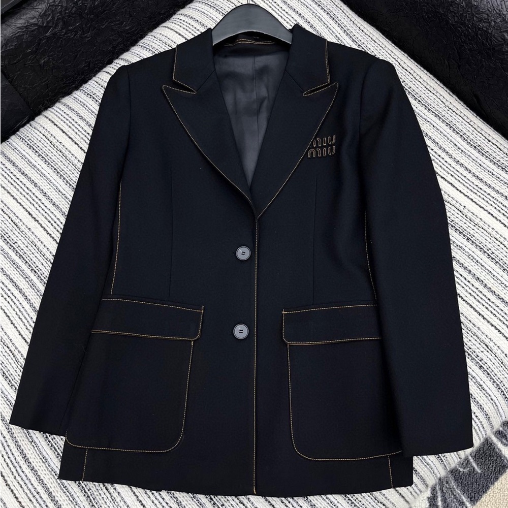 Miu Miu's black suit jacket features contrasting color lines